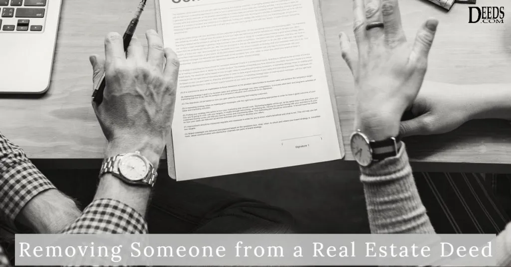 Image of two people at a desk with real estate deed discussing removing one of them from the deed.
